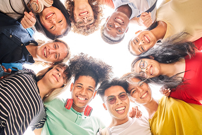 Group of high schoolers in a circle looking down at camera