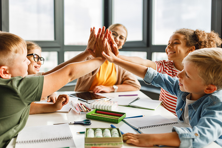 teacher giving students high five at school